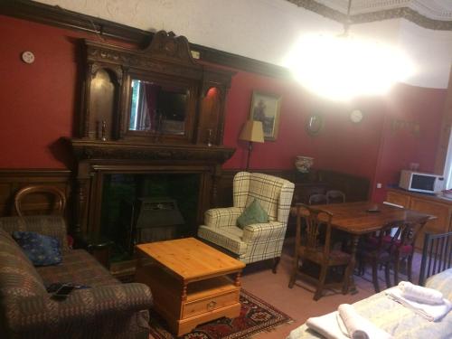 a living room with a fireplace and a table at Newhall in Glasgow