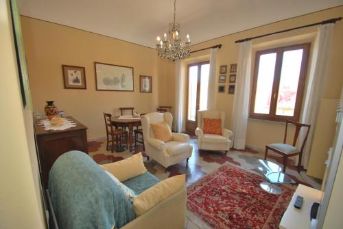 a living room with a couch and chairs and a table at Casa Lidia - Centrale con balcone vista mare e aria condizionata in Capoliveri