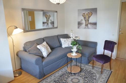a living room with a blue couch and a table at Hotell & Spa Lögnäs Gård in Laholm