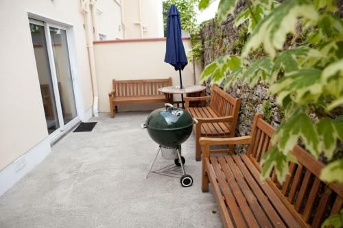 a bbq grill sitting on a patio next to two benches at Waterfront Self Catering Houses in Carrick on Shannon