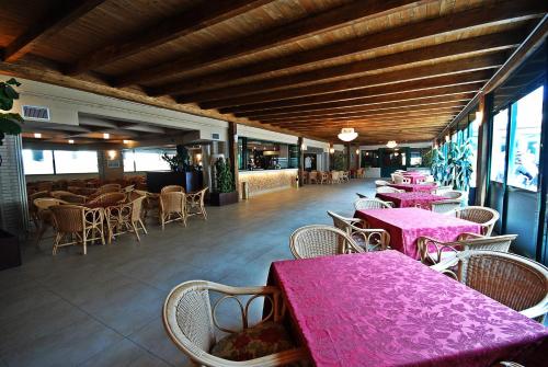 a restaurant with tables and chairs with pink tables at Hotel Dante Family Spa Resort in Cervia