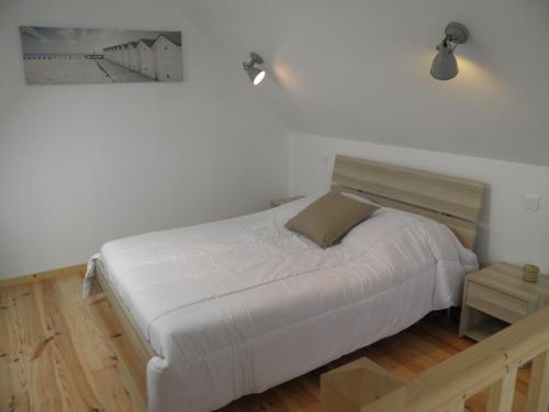 プルゲルノーにあるChez Jeannetteのベッドルーム1室(壁に絵が描かれた白いベッド1台付)