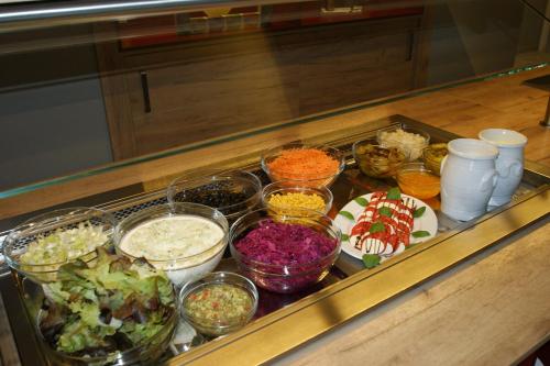 a buffet with bowls of different types of food at Hotel Restaurant Tychon AG in Eynatten