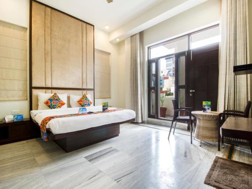 - une chambre avec un lit, une table et une fenêtre dans l'établissement FabHotel Jaipur Villa, à Jaipur
