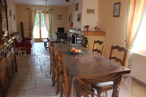 a dining room with a wooden table and chairs at Les Louchardes in La Rochepot