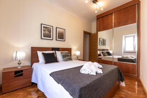 a bedroom with a large bed with towels on it at Like-home Casa Campolide in Lisbon