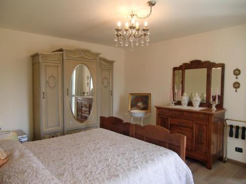 sypialnia z łóżkiem, komodą i lustrem w obiekcie B&B LA VIGNA DI TINA w mieście Costigliole dʼAsti