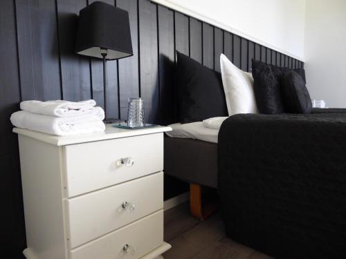 a black and white bedroom with a bed and a nightstand at Holmen in Sorsele