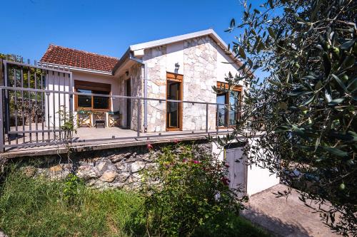 a stone house with a porch and a balcony at Holiday home Haustor with Skadar lake view in Podgorica