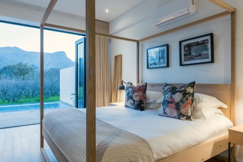 una camera da letto con un letto e una grande finestra di La Chataigne Wines & Guest Cottages a Franschhoek