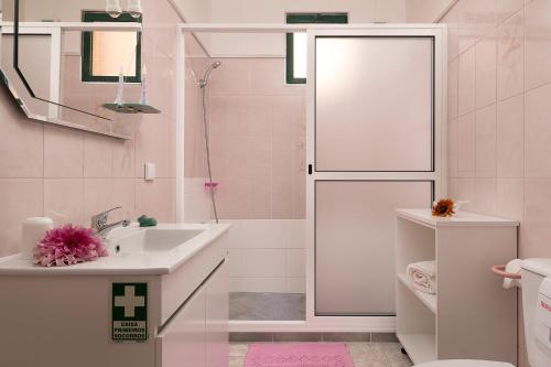 een roze badkamer met een wastafel en een toilet bij Casa do Miradouro in Ponta do Sol