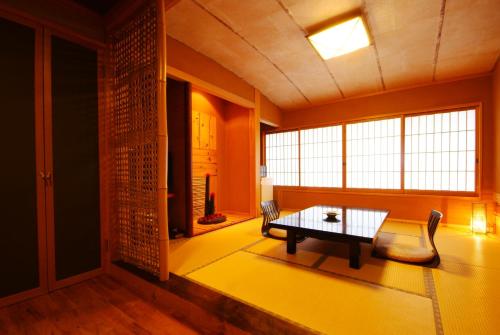 een woonkamer met een tafel, een bank en een raam bij 城崎温泉 但馬屋-Tajimaya- in Toyooka