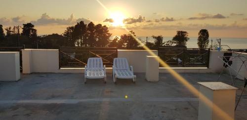 two chairs sitting on a balcony with the sunset at Wonderland in Chakvi