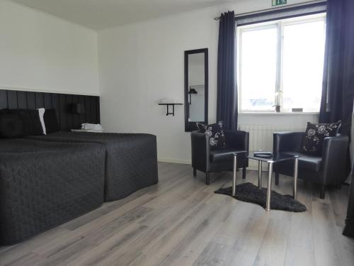 a bedroom with a bed and two chairs and a table at Holmen in Sorsele