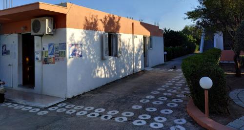 a small white building with a shadow on the side of it at Kyriakos Studios in Afantou