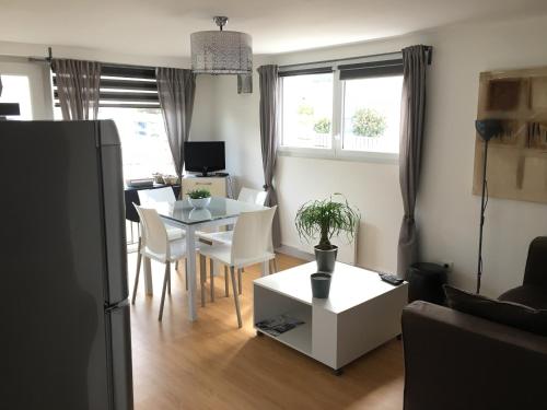 une cuisine et un salon avec une table et des chaises dans l'établissement Cosy's Sable, à Larmor-Plage