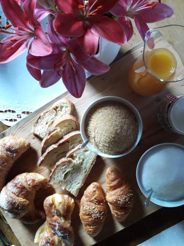 a table with a plate of bread and pastries and flowers at Piccola Corte Antica in Corticelle Pieve