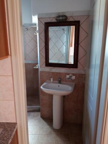 y baño con lavabo y espejo. en Apodrasi en Stení