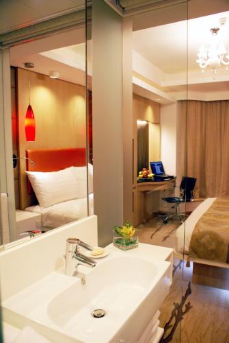 a bathroom with a sink and a bed and a mirror at Stanford Hillview Hotel Hong Kong in Hong Kong