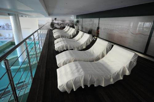 a row of white beds in a room at Hotel Dante Family Spa Resort in Cervia