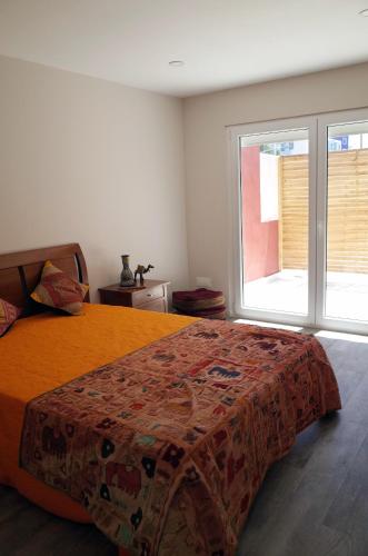 a bedroom with a bed with a blanket on it at Lisbon Beach Apartments 8 in Costa da Caparica