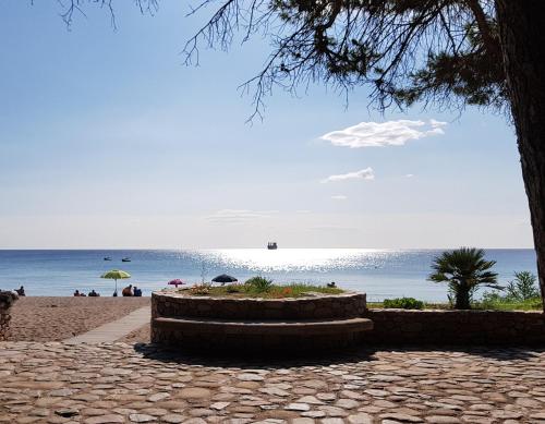 a beach with people on the sand and the ocean at Casa Sa serra in Lotzorai