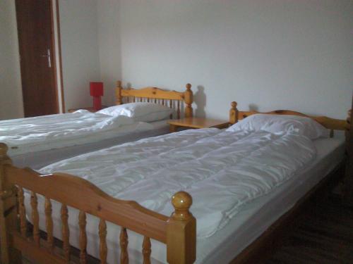 a bedroom with two twin beds with white sheets at Gîte communal in Futeau