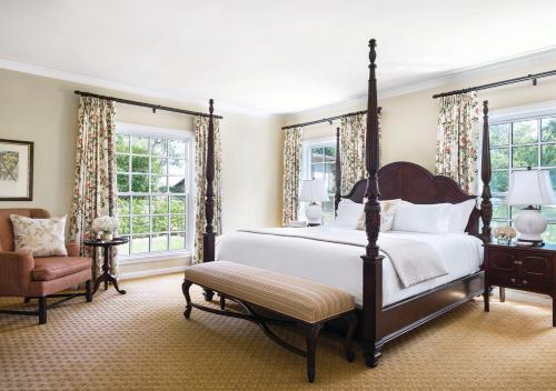a bedroom with a bed and a chair and windows at The Langham Huntington, Pasadena in Pasadena