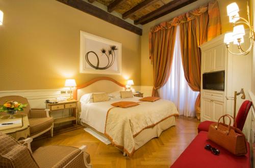 Hotel Corona d'Oro في بولونيا: غرفه فندقيه بسرير وكرسي