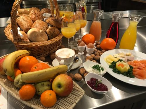 a table with a basket of fruit and other foods at HHotel Augsburg in Augsburg