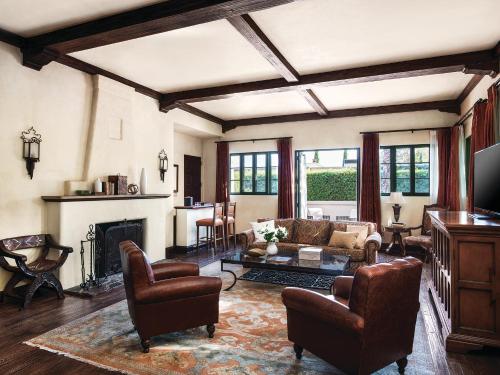 a living room with a couch and a fireplace at The Langham Huntington, Pasadena in Pasadena