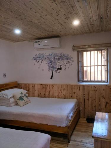 Postel nebo postele na pokoji v ubytování Nanjing Tulou Qingdelou Inn
