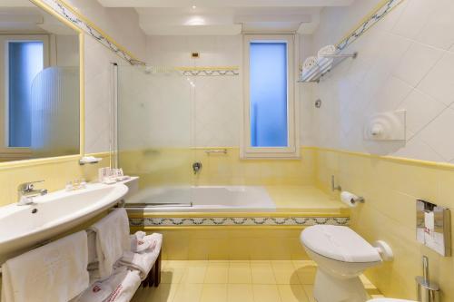a bathroom with a tub and a toilet and a sink at Hotel Continental in Sorrento