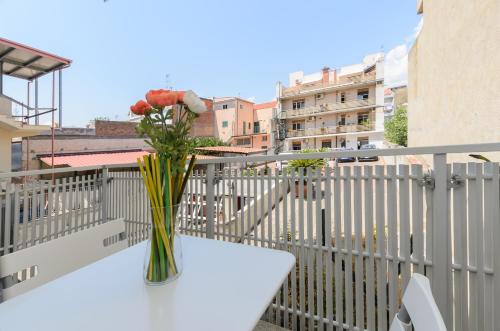 a vase of flowers sitting on a table on a balcony at Marina D'Agrò Residence in Santa Teresa di Riva