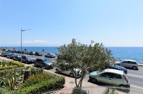 a parking lot with cars parked next to the ocean at Marina D'Agrò Residence in Santa Teresa di Riva