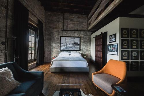 a bedroom with a bed and a couch and a chair at GunRunner Boutique Hotel in Florence