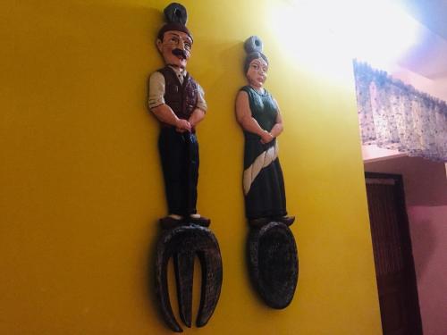 two wooden statues of a man and a woman on a wall at 叁樓民宿 in Taitung City