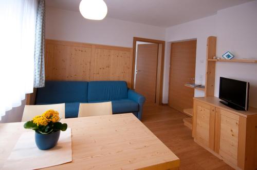 a living room with a blue couch and a table at Gasthof Traube in San Lorenzo di Sebato