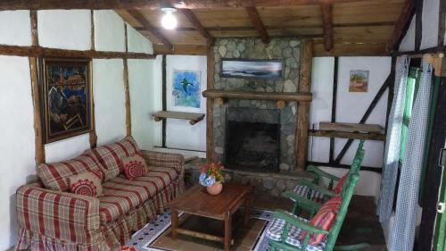 a living room with a couch and a fireplace at Villa Pajon Eco Lodge in Constanza