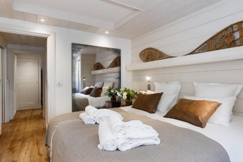 a bedroom with a large bed with towels on it at Annapurna by Alpine Resorts in Les Gets