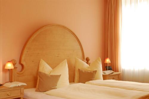 a bedroom with two beds with a large headboard at Kurhotel Fürstenhof by David in Blankenburg