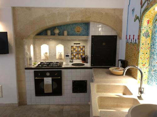 una cocina con fregadero y estufa horno superior en “Il Mosaico” Suite Apartment - Grottaglie, en Grottaglie
