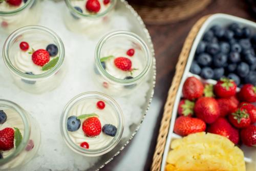 a table topped with bowls of fruit and desserts at Hotel Wegner - T h e culinary art hotel in Hannover