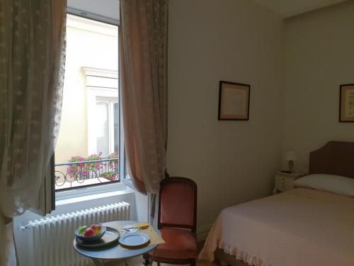 a room with a bed and a table and a window at Al centro Luxury Home in Caserta