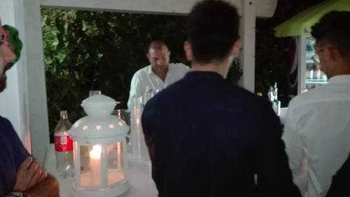 a group of people standing around a table with a man at L'Isola Felice e Trulli Sotto Le Stelle in Castellana Grotte