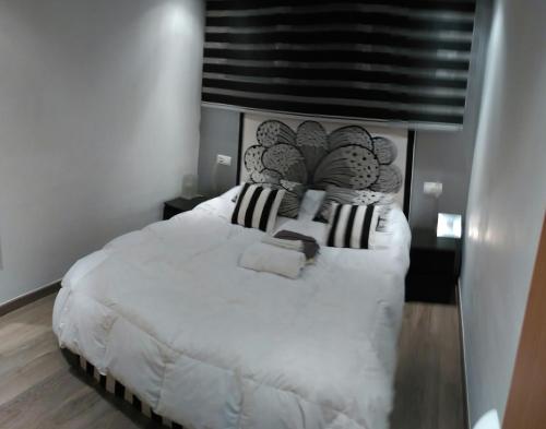シエラネバダにあるApartamento edificio Sierralacantのベッドルーム(白い大型ベッド1台、ヘッドボード付)