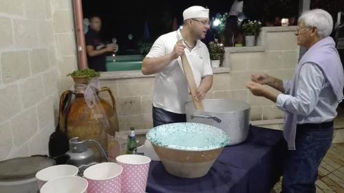two men standing in a kitchen making a cake at L'Isola Felice e Trulli Sotto Le Stelle in Castellana Grotte