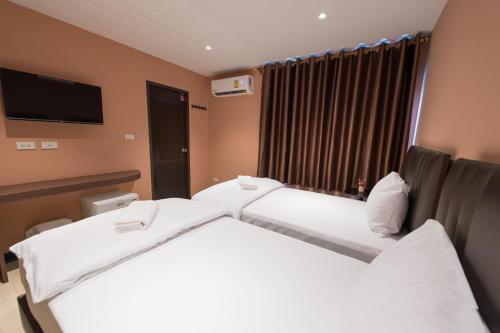 a hotel room with two beds and a flat screen tv at Let's Zzz Bangkok in Bangkok