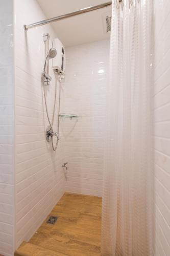 a shower with a white shower curtain in a bathroom at Let's Zzz Bangkok in Bangkok
