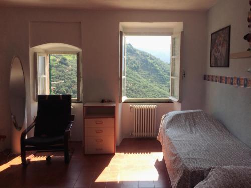 a bedroom with a bed and a chair and a window at Cinqueterre - Terrace and beautiful view in Levanto